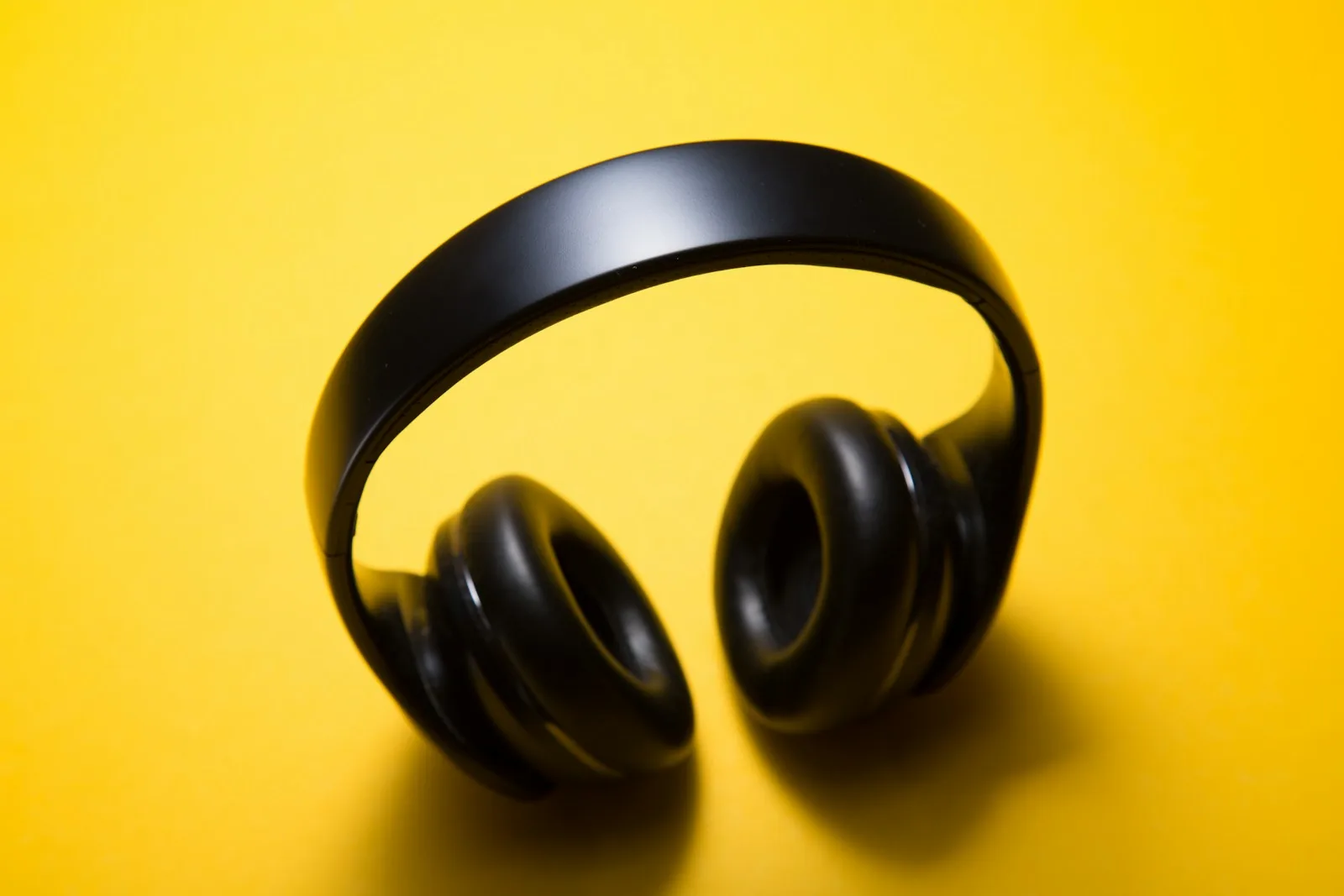 Wireless over-ear headphones on a yellow surface