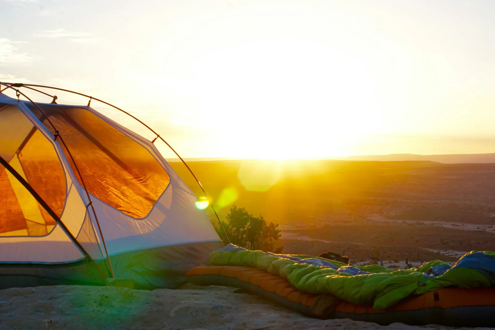 Camping tent on a rocky viewpoint at sunrise