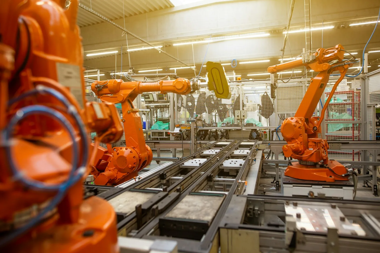 Orange industrial robotic arms in an automated factory