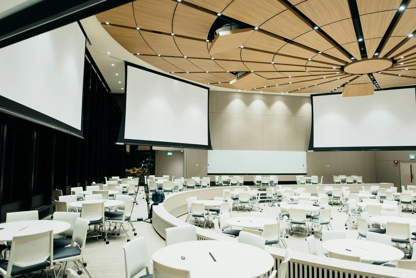 Conference venue with round tables and projection screens